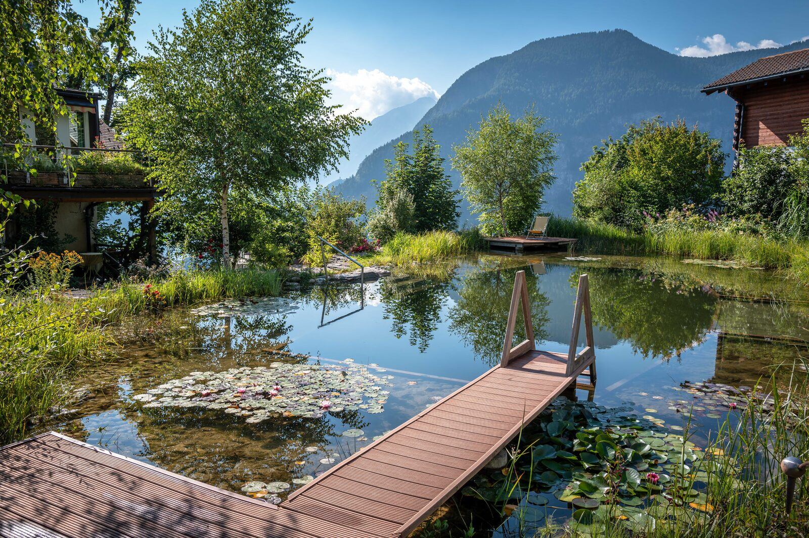 Naturpool mit Steg und Blick in die Berge