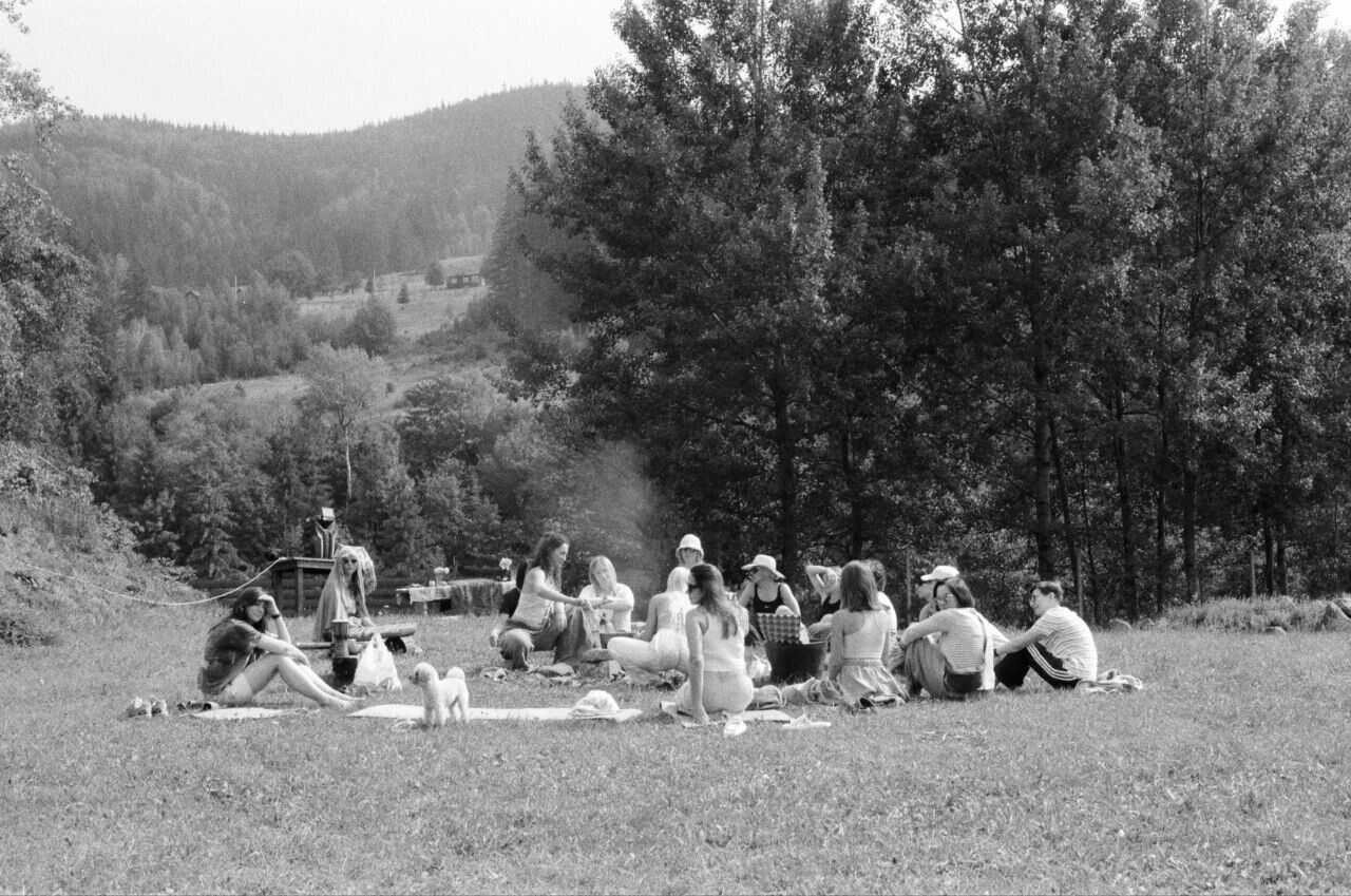 Schwarzweissbild: Gruppe auf einer Wiese am Waldrand